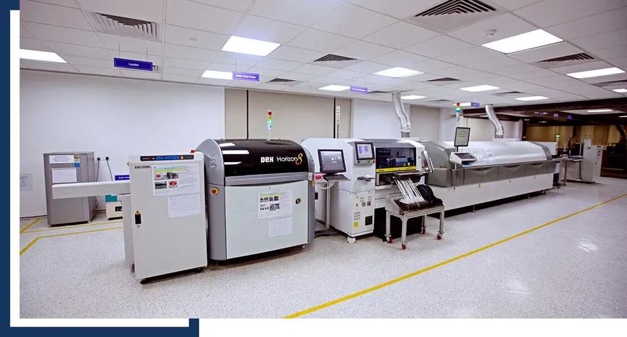 An SMT assembly line in operation with various machines.