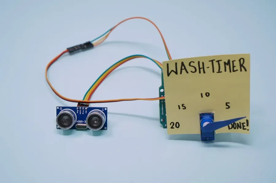 A person working on a hobby electronics project with a PCB.