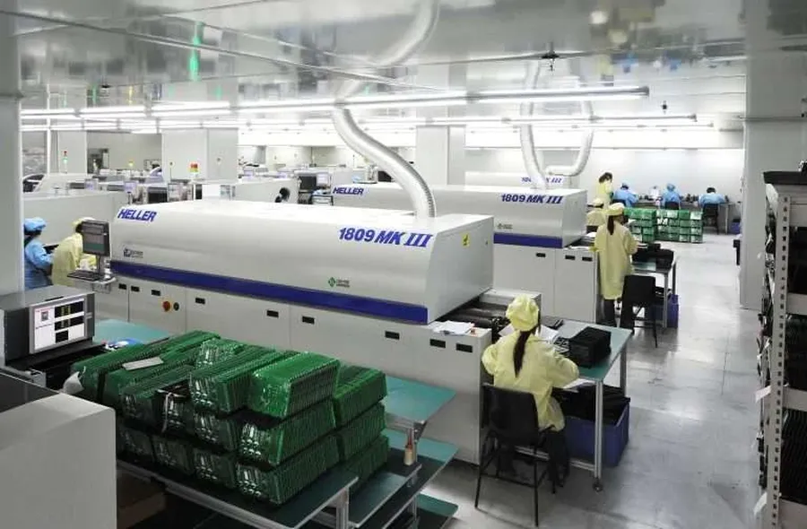 An overview of a PCB manufacturing workshop with workers and machinery.