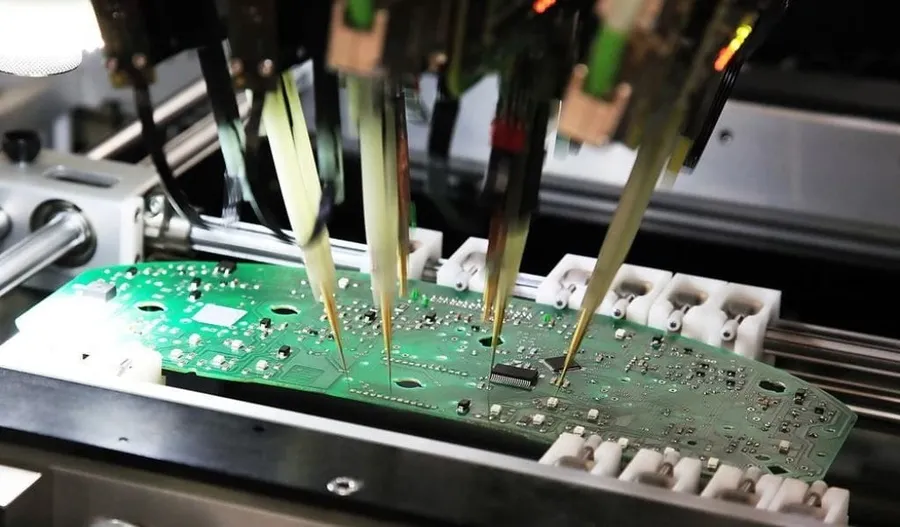 Technicians testing a PCB for quality control.