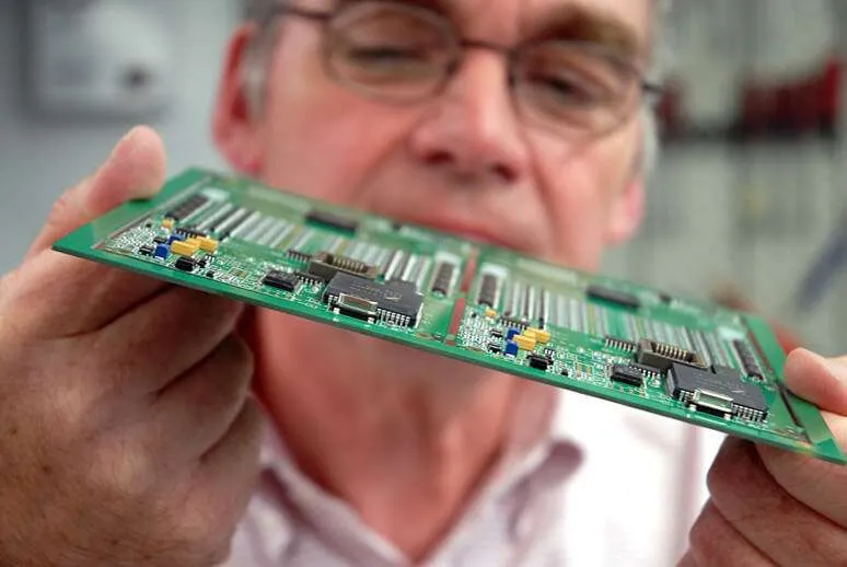 A technician inspecting assembled PCBs for quality.
