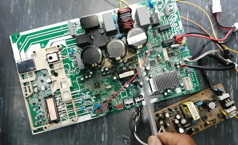 A damaged air conditioner PCB board showing signs of burning or failure.